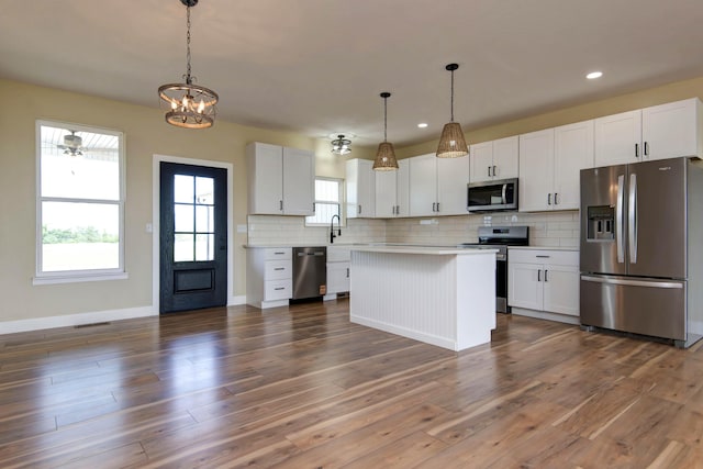 1883 S Farm Rd Unit 107, Springfield, MO 65802 - kitchen with stainless steel appliances, light countertops, a sink, backsplash, and white cabinets