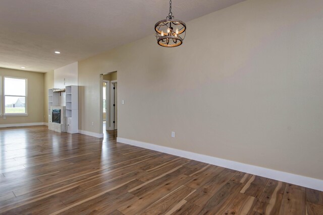 1883 S Farm Rd Unit 107, Springfield, MO 65802 - unfurnished living room featuring a chandelier, baseboards, dark wood-style flooring, and recessed lighting