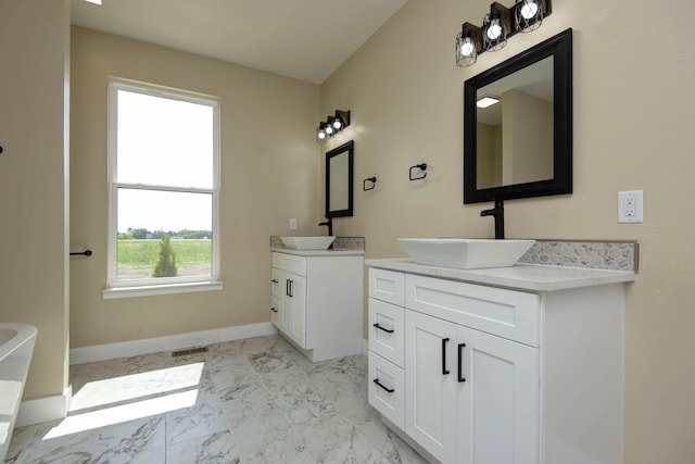 1883 S Farm Rd Unit 107, Springfield, MO 65802 - bathroom featuring two vanities, marble look tiles, baseboards, and a bath
