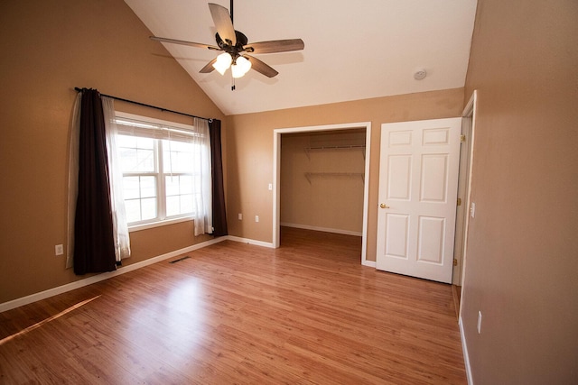 unfurnished bedroom with visible vents, lofted ceiling, baseboards, and light wood finished floors