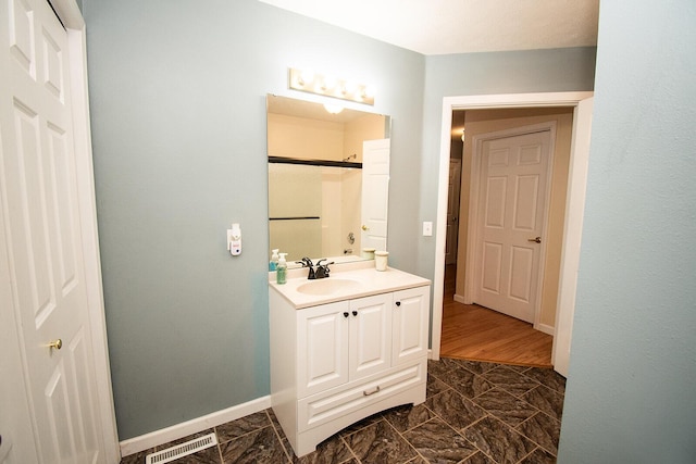 full bathroom featuring vanity, baseboards, and visible vents