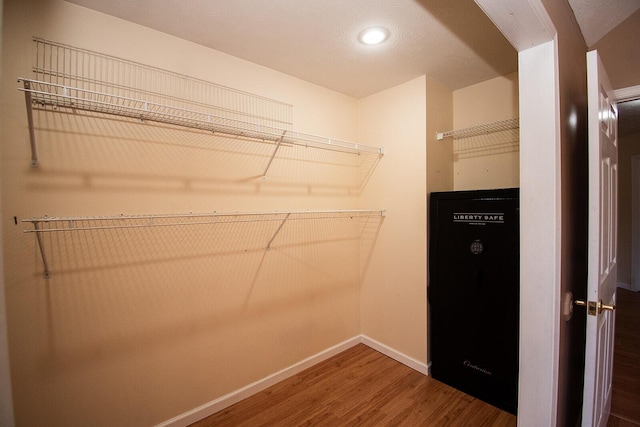 walk in closet with wood finished floors