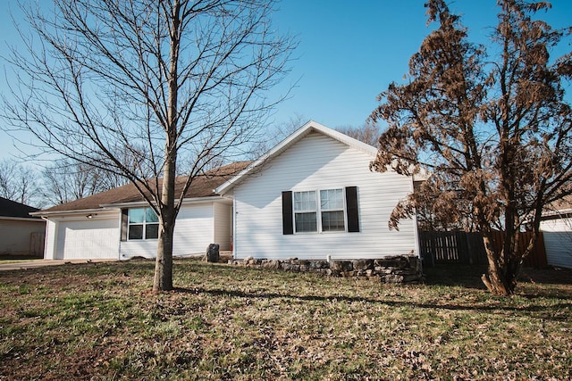 view of front facade with a garage, a front yard, and fence