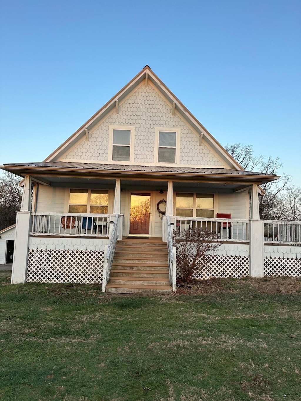 view of front of home with covered porch and a front lawn