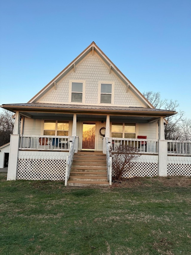 view of front of home with covered porch and a front lawn