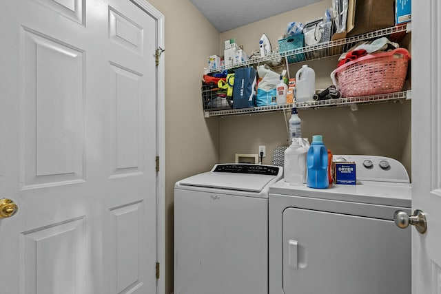 clothes washing area featuring washer and dryer, a textured ceiling, and laundry area