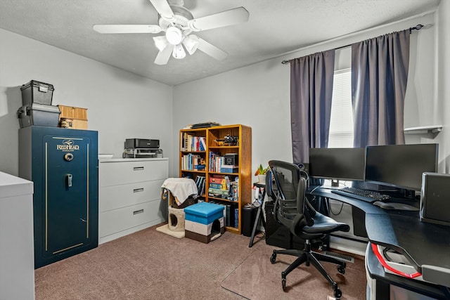 carpeted home office with a textured ceiling and ceiling fan