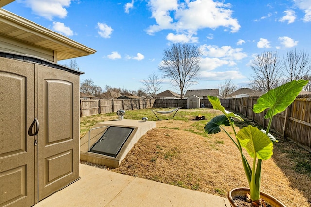 entry to storm shelter featuring an outdoor structure, a fenced backyard, a lawn, and a shed