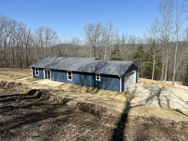 exterior space featuring driveway and a view of trees