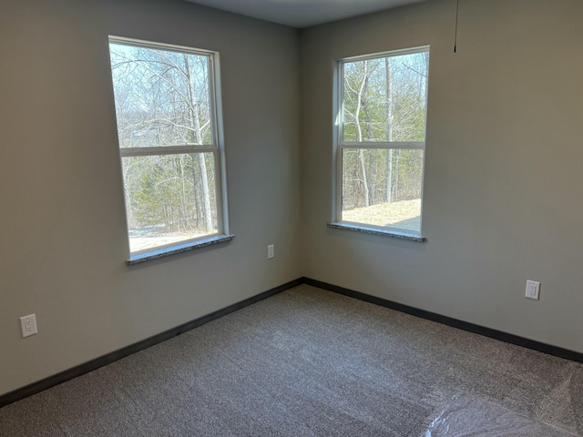 carpeted empty room with baseboards