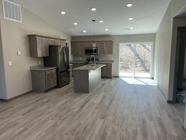 kitchen featuring visible vents, appliances with stainless steel finishes, light wood-style floors, and a sink