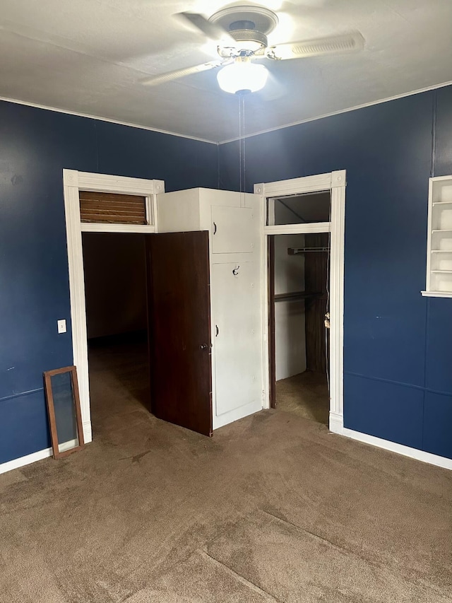 unfurnished bedroom featuring a closet, baseboards, a ceiling fan, and carpet flooring