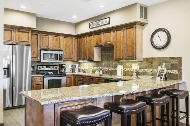 201 Prairie Dunes Dr Unit 1307/1308, Branson, MO 65616 - kitchen featuring visible vents, backsplash, appliances with stainless steel finishes, a peninsula, and light stone countertops