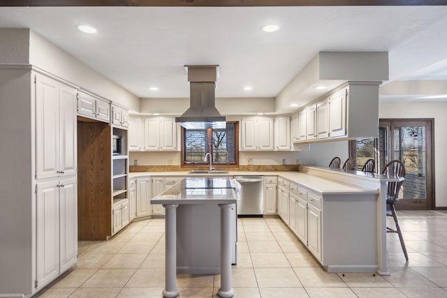 kitchen with stainless steel dishwasher, a breakfast bar, plenty of natural light, and a sink