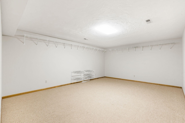 unfurnished room featuring visible vents, baseboards, carpet, and a textured ceiling