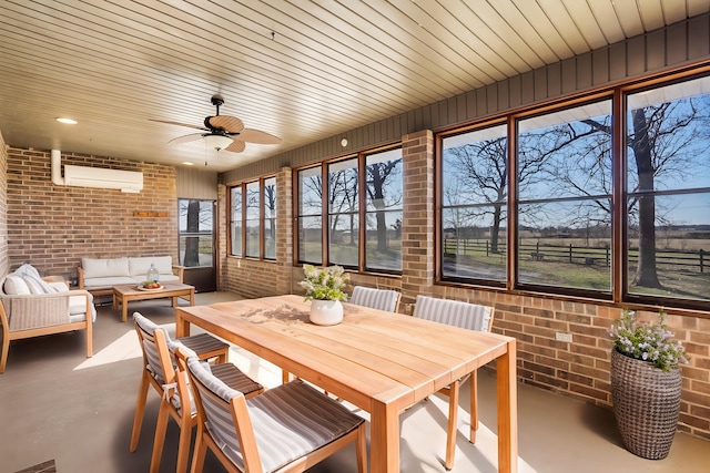 sunroom with a ceiling fan and a wall mounted air conditioner