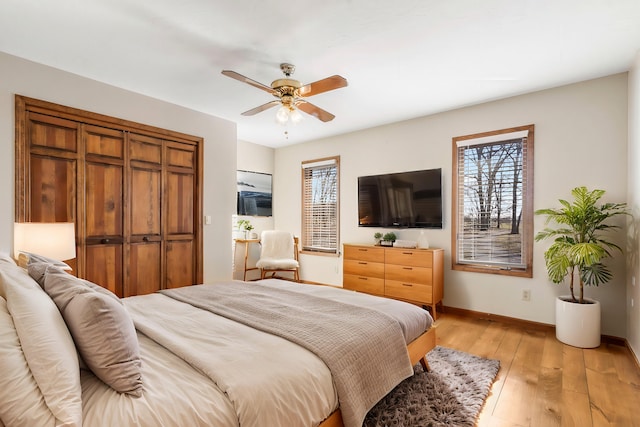 bedroom with baseboards, a ceiling fan, and light wood finished floors