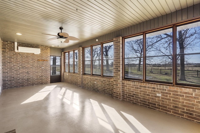 unfurnished sunroom featuring a wall mounted air conditioner and ceiling fan