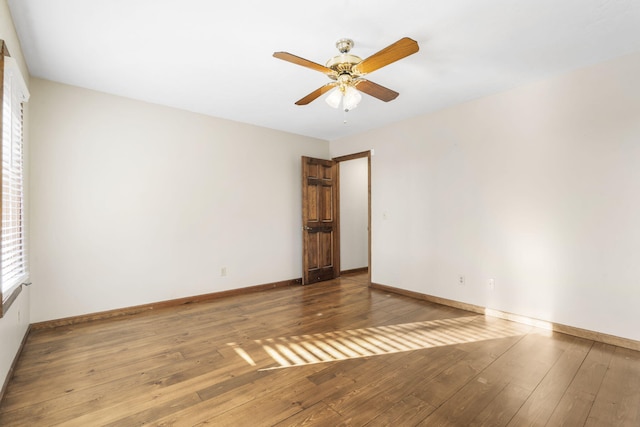 empty room with ceiling fan, baseboards, and hardwood / wood-style flooring