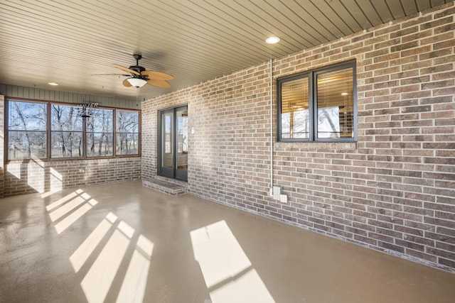 unfurnished sunroom featuring a ceiling fan and a wealth of natural light