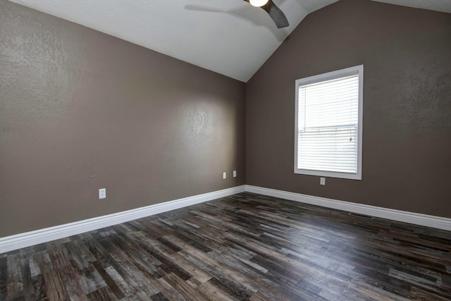 spare room with vaulted ceiling, dark wood-style floors, baseboards, and ceiling fan