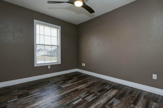 spare room with dark wood finished floors, visible vents, baseboards, and ceiling fan