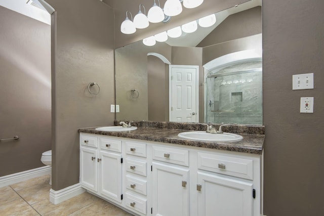 full bathroom featuring a sink, toilet, a stall shower, and tile patterned flooring