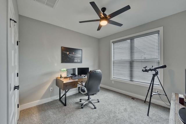 carpeted home office featuring a ceiling fan, visible vents, and baseboards