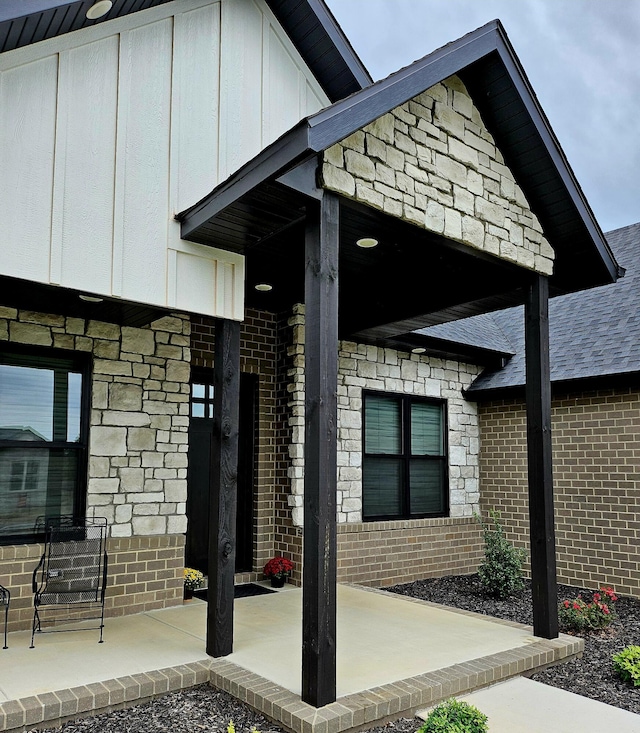 doorway to property featuring brick siding and board and batten siding