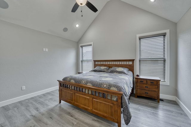 bedroom with ceiling fan, high vaulted ceiling, baseboards, and wood finished floors