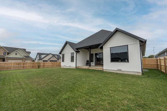 back of property with a lawn, a fenced backyard, and a patio area