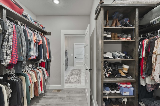 walk in closet featuring wood finished floors and visible vents