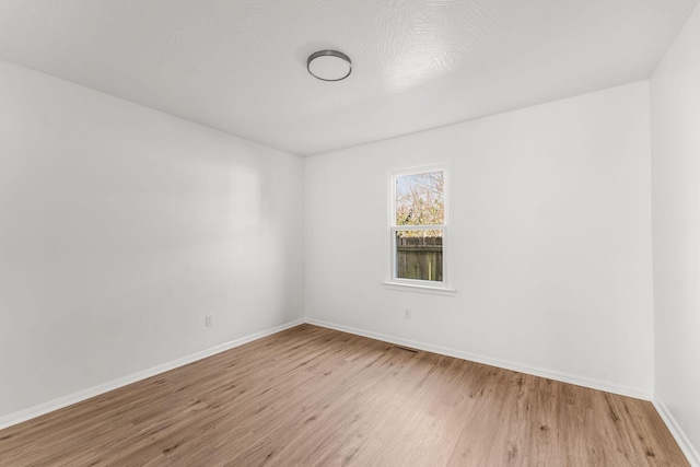 spare room with light wood-style floors and baseboards