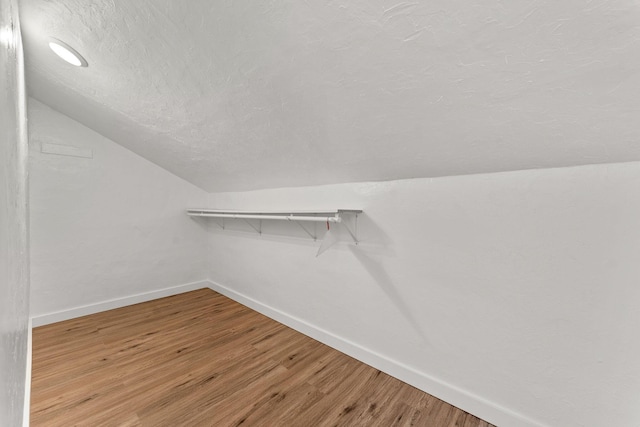 spacious closet featuring light wood-style floors and vaulted ceiling