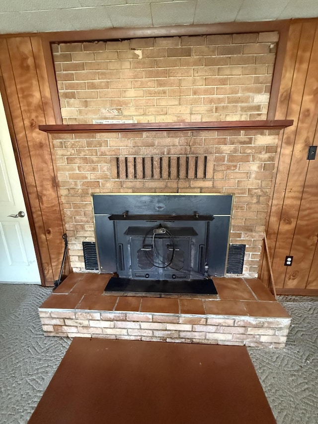 details featuring visible vents, a wood stove, and carpet floors