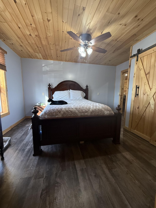 bedroom featuring dark wood finished floors, wooden ceiling, and a barn door