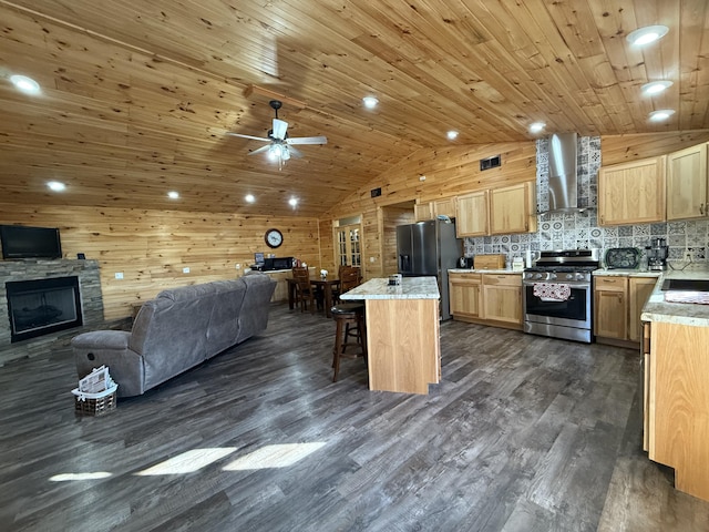 kitchen with open floor plan, stainless steel appliances, wall chimney exhaust hood, and vaulted ceiling