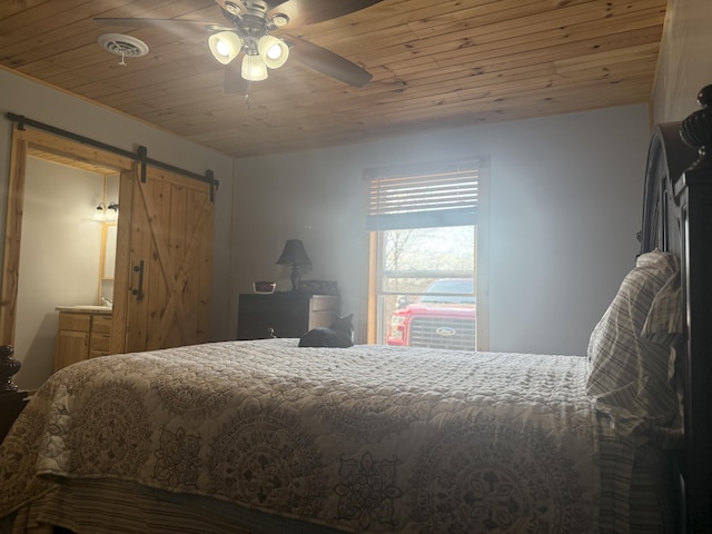 bedroom featuring a barn door, a ceiling fan, visible vents, and wooden ceiling