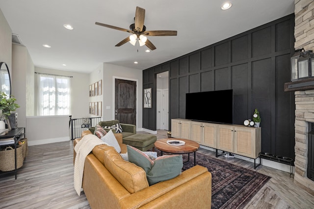 living area featuring a decorative wall, recessed lighting, light wood-style floors, and ceiling fan