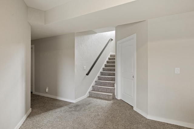 below grade area with stairs, carpet flooring, and baseboards