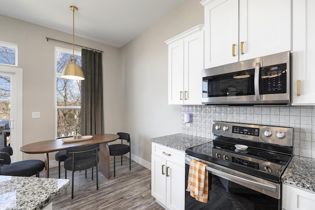 kitchen with tasteful backsplash, white cabinetry, stainless steel appliances, stone counters, and baseboards