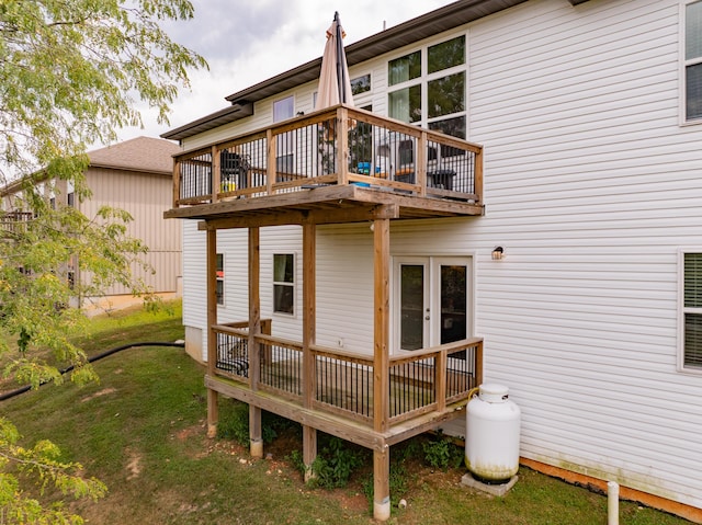 rear view of property featuring a lawn and a deck