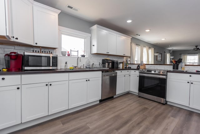 kitchen featuring a sink, visible vents, dark countertops, and appliances with stainless steel finishes