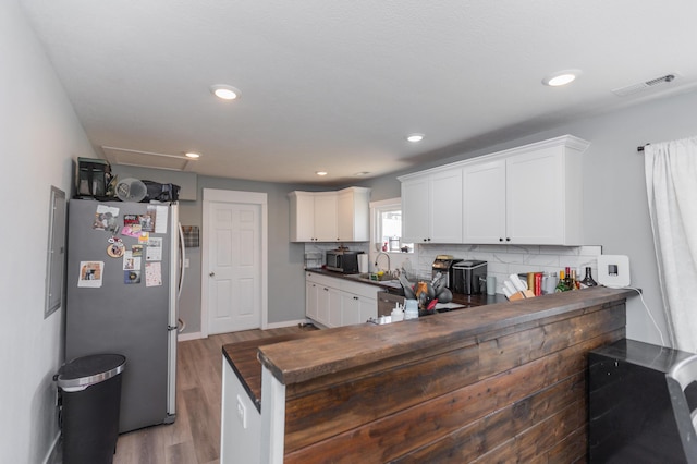 kitchen with dark countertops, visible vents, backsplash, white cabinets, and stainless steel appliances