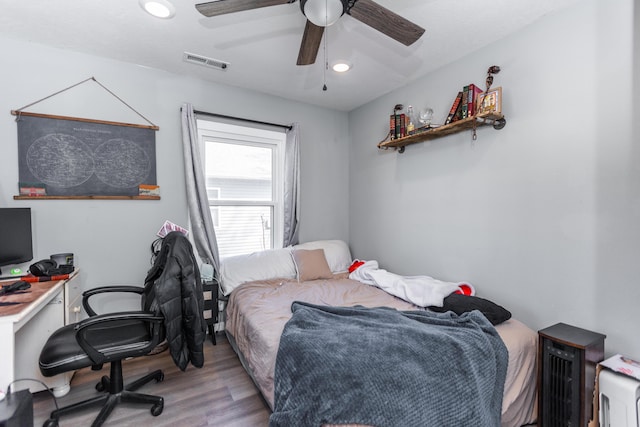 bedroom featuring visible vents, wood finished floors, and a ceiling fan