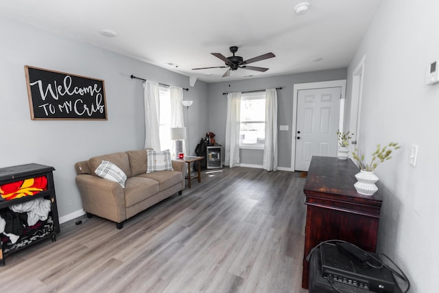 living room with baseboards, a ceiling fan, and wood finished floors