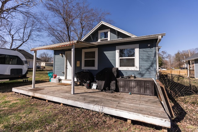 rear view of property featuring a wooden deck and fence