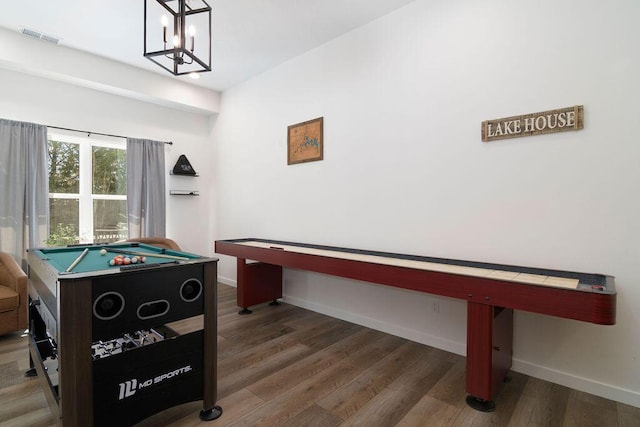 recreation room featuring visible vents, baseboards, an inviting chandelier, and wood finished floors