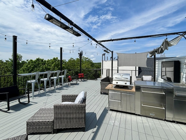 wooden terrace featuring grilling area and an outdoor kitchen