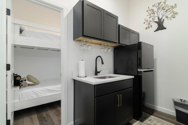 ensuite bathroom featuring vanity, wood finished floors, baseboards, and connected bathroom